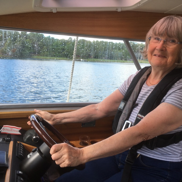 Kvinna kör sin kabinbåt som hon ägt sedan länge redo för avfärd till ny brygga.