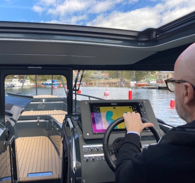 Man övar tilläggning i motorbåt i trång hamn med många bojar och ankarlinor, Malma kvarn Stockholms skärgård.